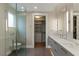 Stylish bathroom with dual sinks, modern fixtures, glass-enclosed shower, and access to a walk-in closet at 505 Dragon Gate Ct, Henderson, NV 89012