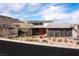 Contemporary home featuring modern design, desert landscaping, and a unique stone and wood facade at 505 Dragon Gate Ct, Henderson, NV 89012