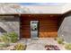 Up close front door with wood paneling and desert landscaping adding curb appeal to the modern home at 505 Dragon Gate Ct, Henderson, NV 89012