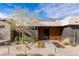 Beautiful desert landscaping graces the walkway of the modern home with a wood paneled entryway at 505 Dragon Gate Ct, Henderson, NV 89012