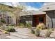 Beautiful desert landscaping graces the walkway of the modern home with a wood paneled entryway at 505 Dragon Gate Ct, Henderson, NV 89012