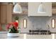 Beautiful kitchen with a marble backsplash, chef's stove, and pendant lighting above island at 505 Dragon Gate Ct, Henderson, NV 89012