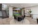 Open-concept living area with staircase, game table, modern decor, and views of the outdoor green space at 505 Dragon Gate Ct, Henderson, NV 89012