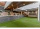 Expansive outdoor recreational room with a projector, artificial turf, retaining wall, and rock landscaping at 505 Dragon Gate Ct, Henderson, NV 89012