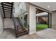 Elegant staircase with wood steps, metal railings, and expansive windows offering views of an outdoor green area at 505 Dragon Gate Ct, Henderson, NV 89012