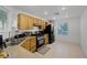 Bright kitchen with stainless steel appliances, light wood cabinets, and neutral tile flooring at 5081 Pine Mountain Ave, Las Vegas, NV 89139