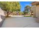 Spacious backyard featuring mature landscaping, a block wall, and a large concrete slab at 5628 Crimson Ridge Dr, Las Vegas, NV 89130