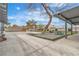Extensive backyard area with a concrete patio, lush lawn, and mature trees providing ample shade at 5700 N Torrey Pines Dr, Las Vegas, NV 89130