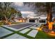 View of a driveway with large trees and exterior landscape lighting at 5700 N Torrey Pines Dr, Las Vegas, NV 89130