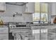 Close-up of the kitchen featuring stainless steel range and herringbone tile backsplash at 5700 N Torrey Pines Dr, Las Vegas, NV 89130