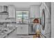 Bright kitchen showcasing white cabinets, stainless steel appliances, and granite countertops with a window view at 5700 N Torrey Pines Dr, Las Vegas, NV 89130