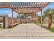 Expansive pergola-covered patio with built-in seating and lush landscaping for outdoor enjoyment at 5700 N Torrey Pines Dr, Las Vegas, NV 89130