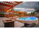Inviting pool area featuring a pergola with ambient lighting and a comfortable seating area at 5700 N Torrey Pines Dr, Las Vegas, NV 89130