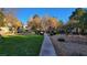 A sidewalk cuts through a green, tree-lined common area in this well-maintained apartment complex at 5710 E Tropicana Ave # 2049, Las Vegas, NV 89122
