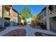 Exterior view of well-maintained condo buildings with mature trees and walkways at 5710 E Tropicana Ave # 2049, Las Vegas, NV 89122