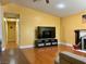 Spacious living room featuring bright yellow walls, TV, and wood floors at 6620 Casa Linda Dr, Las Vegas, NV 89103