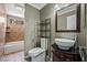 Bathroom featuring tiled walls, vessel sink, decorative mirror, and a shower/tub combination at 715 Rusty Spur Dr, Henderson, NV 89014