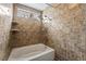 Bathroom featuring tiled walls, tiled shower with rainfall showerhead, and built-in shelving at 715 Rusty Spur Dr, Henderson, NV 89014