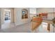 Upstairs hallway featuring carpet flooring, built-in shelving, and wooden banister at 7420 Enchanted Hills Ct, Las Vegas, NV 89129