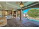 An outdoor kitchen with stone accents, a fireplace, and a view of the refreshing pool area at 7420 Enchanted Hills Ct, Las Vegas, NV 89129