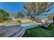 Backyard pool with manicured artificial grass, lounge chairs, and a tranquil setting at 7420 Enchanted Hills Ct, Las Vegas, NV 89129