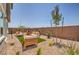 Landscaped backyard with modern patio furniture, a playhouse, and a gravel groundcover, offering a relaxing outdoor space at 7449 Bosco Dr # Lot 106, North Las Vegas, NV 89084