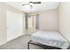Simple bedroom with a ceiling fan, window, closet, and neutral carpet flooring at 7486 River Dove Ct, Las Vegas, NV 89139