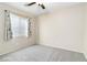 Carpeted bedroom with a ceiling fan, window with blinds, and neutral walls at 7486 River Dove Ct, Las Vegas, NV 89139
