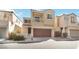 Two-story home featuring a large garage door, balcony, and neutral stucco exterior with charming curb appeal at 7486 River Dove Ct, Las Vegas, NV 89139