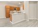 A modern kitchen with wood cabinets, stainless steel appliances, and an island with a white countertop at 7486 River Dove Ct, Las Vegas, NV 89139
