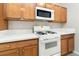 Close-up of the kitchen with stainless steel oven, microwave, and wood cabinets at 7486 River Dove Ct, Las Vegas, NV 89139