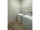 Convenient laundry room with tile flooring, shelving, and white washer and dryer at 8250 N Grand Canyon Dr # 2085, Las Vegas, NV 89166