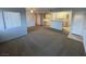 A carpeted living room with natural light and an open layout into the kitchen at 8250 N Grand Canyon Dr # 2085, Las Vegas, NV 89166