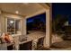 Covered back patio features a dining area seen through sliding glass doors, as well as stylish, comfortable seating at 10172 Bismarck Palms Ave, Las Vegas, NV 89166