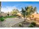 Landscaped backyard with a brick patio, dining set, grass, and well-maintained plants and trees at 10172 Bismarck Palms Ave, Las Vegas, NV 89166
