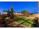 A lovely backyard provides desert landscaping, artificial lawn, and bench seating to enjoy the outdoors at 10172 Bismarck Palms Ave, Las Vegas, NV 89166