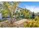 Landscaped backyard featuring a brick patio with dining set, and mature trees in a lush green yard at 10172 Bismarck Palms Ave, Las Vegas, NV 89166