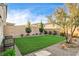 Inviting backyard featuring an artificial lawn, desert landscaping, and a charming bench for relaxing outdoors at 10172 Bismarck Palms Ave, Las Vegas, NV 89166