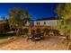 Cozy backyard patio featuring a dining table and chairs, set on a brick paver surface with landscaping and night lighting at 10172 Bismarck Palms Ave, Las Vegas, NV 89166