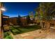Backyard featuring well-manicured synthetic lawn area, complemented by stylish paver accents and desert landscaping at 10172 Bismarck Palms Ave, Las Vegas, NV 89166