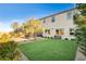 Large backyard offering an artificial lawn, desert landscaping, with patio dining and bench seating at 10172 Bismarck Palms Ave, Las Vegas, NV 89166