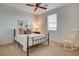 Cozy bedroom with neutral walls, a ceiling fan, natural lighting, and a decorative rocking chair at 10172 Bismarck Palms Ave, Las Vegas, NV 89166