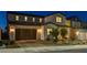 Beautiful two-story home with a dark brown garage door and well-maintained front yard landscaping at dusk at 10172 Bismarck Palms Ave, Las Vegas, NV 89166