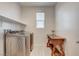 Laundry room featuring front-load washer and dryer, storage shelves and a charming console table at 10172 Bismarck Palms Ave, Las Vegas, NV 89166