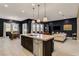 Open-concept living space with kitchen island, dining area, and comfortable seating under modern pendant lighting at 10172 Bismarck Palms Ave, Las Vegas, NV 89166