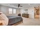 Spacious main bedroom with a ceiling fan, large windows, a dresser and a lounge chair at 10172 Bismarck Palms Ave, Las Vegas, NV 89166