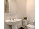 Clean powder room with a pedestal sink, modern toilet, and decorative mirror at 10172 Bismarck Palms Ave, Las Vegas, NV 89166