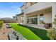 Beautiful backyard featuring lush artificial turf, tiled patio, and thoughtful landscaping for outdoor enjoyment at 10655 Patina Hills Ct, Las Vegas, NV 89135