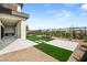 Serene backyard with artificial turf, modern landscaping, and a tiled patio area offers a tranquil outdoor space at 10655 Patina Hills Ct, Las Vegas, NV 89135