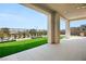 Covered patio features artificial turf, landscaping, and tile flooring, perfect for outdoor relaxation and entertaining at 10655 Patina Hills Ct, Las Vegas, NV 89135